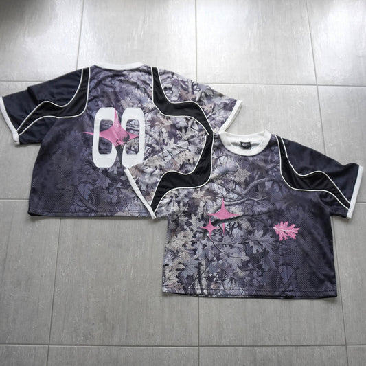 Two camouflage-patterned shirts with white and black designs on a tiled floor.